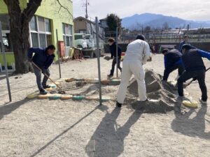 笛吹市御坂町内の保育園で砂入れボランティアを行っている様子。