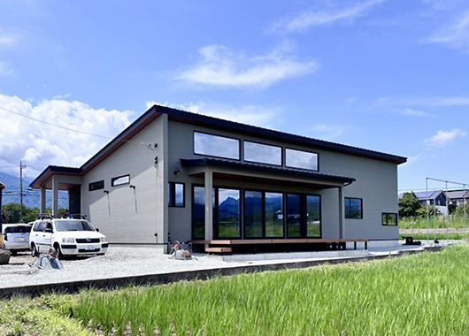 地場工務店の施工事例。水田風景の中に建つ平屋住宅の外観。