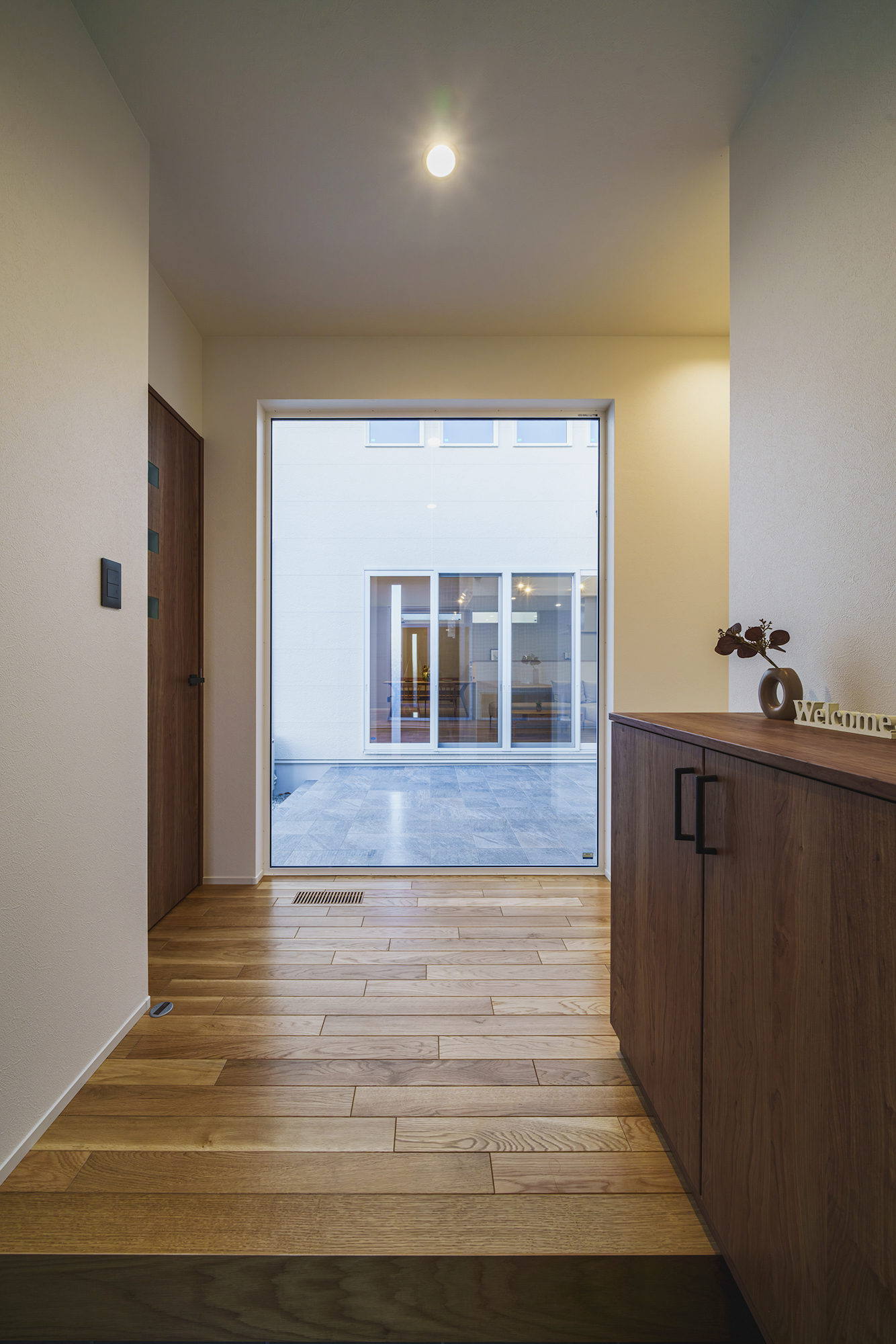 玄関を開けると大きな窓越しに中庭が広がります